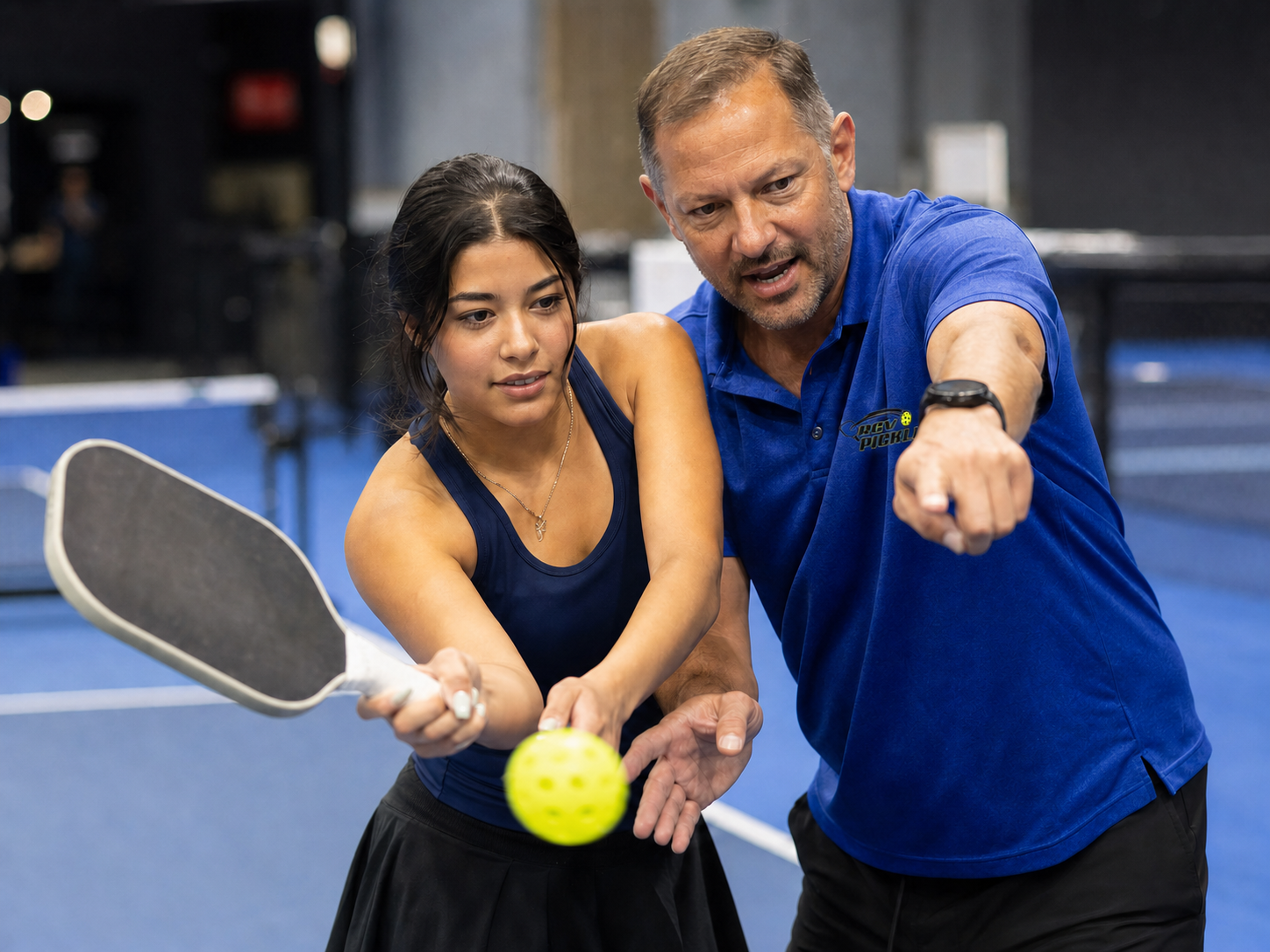 Coach teaching young adult pickleball